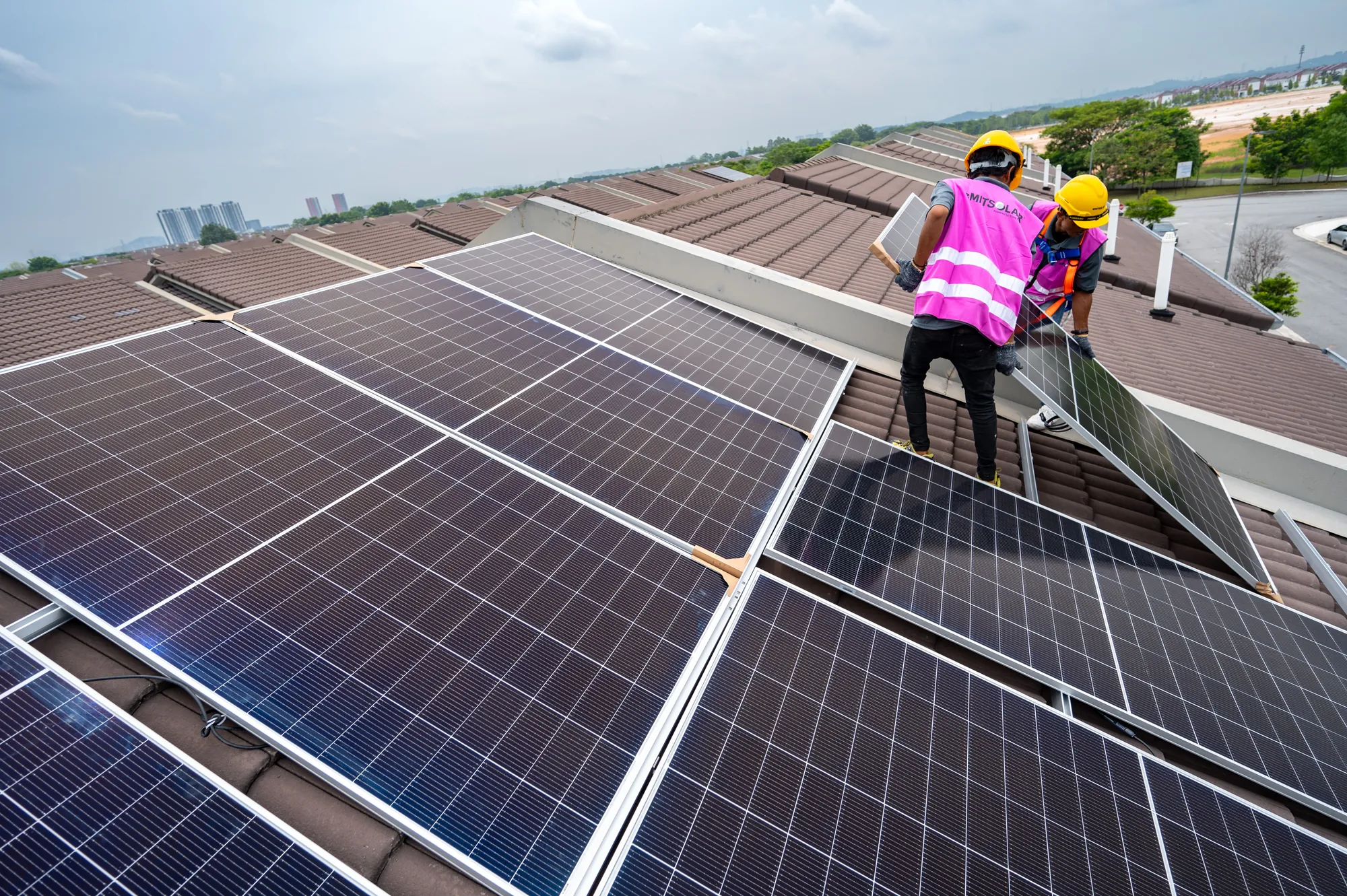 Installers laying panels on the roof